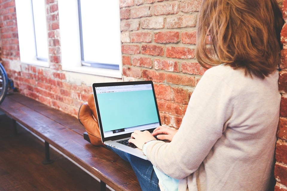 Woman sitting with laptop on her lap